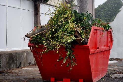 Workers unloading debris into a skip bin